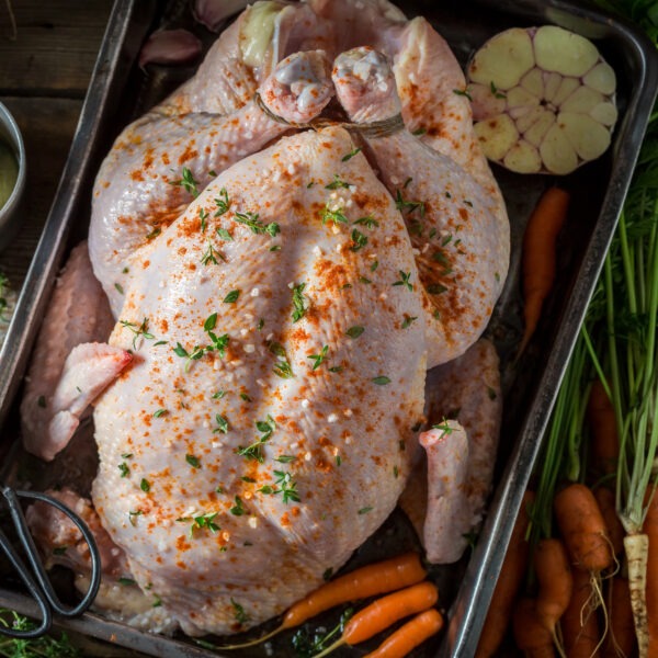 Poulet farci dans plat avec les ingrédients de la farce à côté